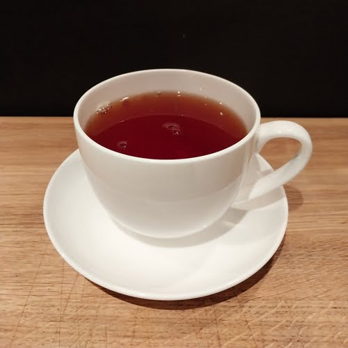White cup and saucer with black tea